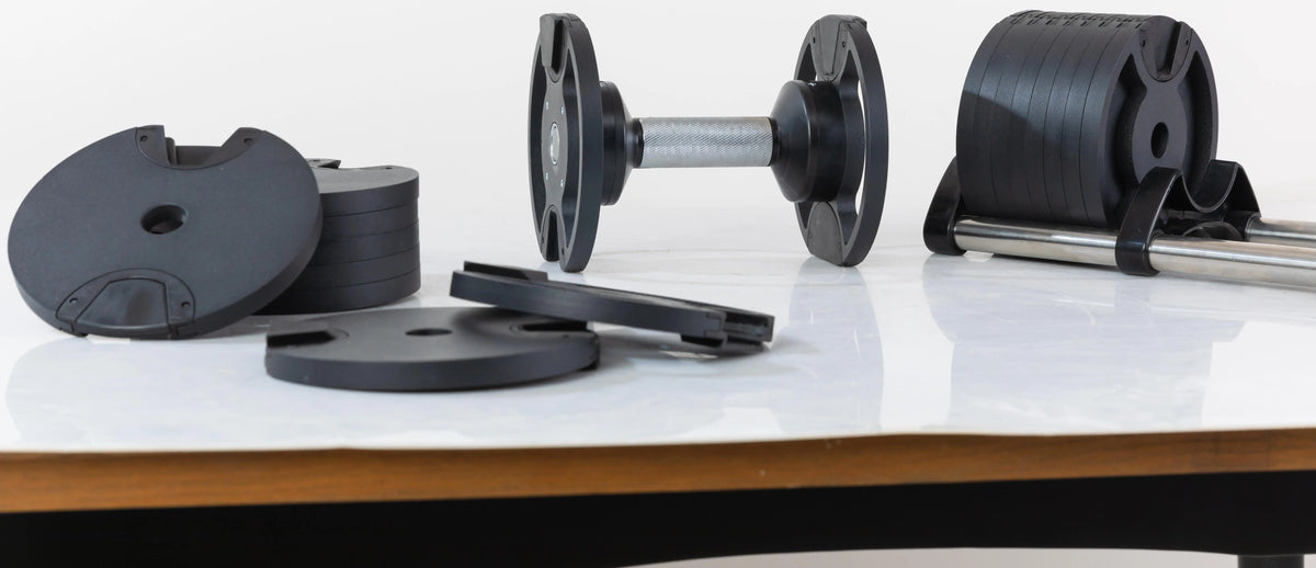 Adjustable Cito Thriven cast iron dumbbells with textured grips and weight plates for strength training workouts.